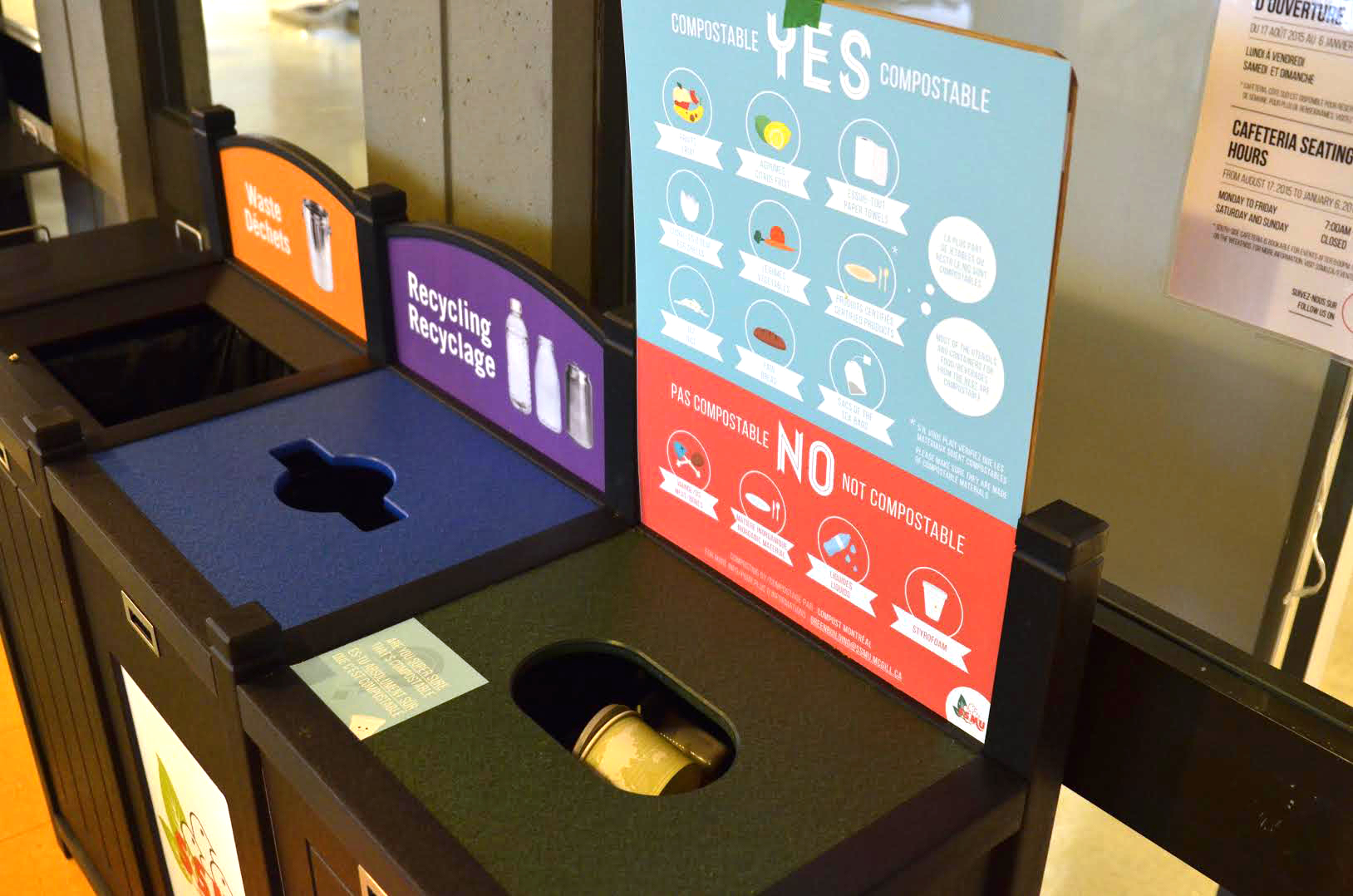 Three waste bins in row, showing garbage, recycling, and composting signs